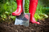 Moestuin met spade en rode laarzen